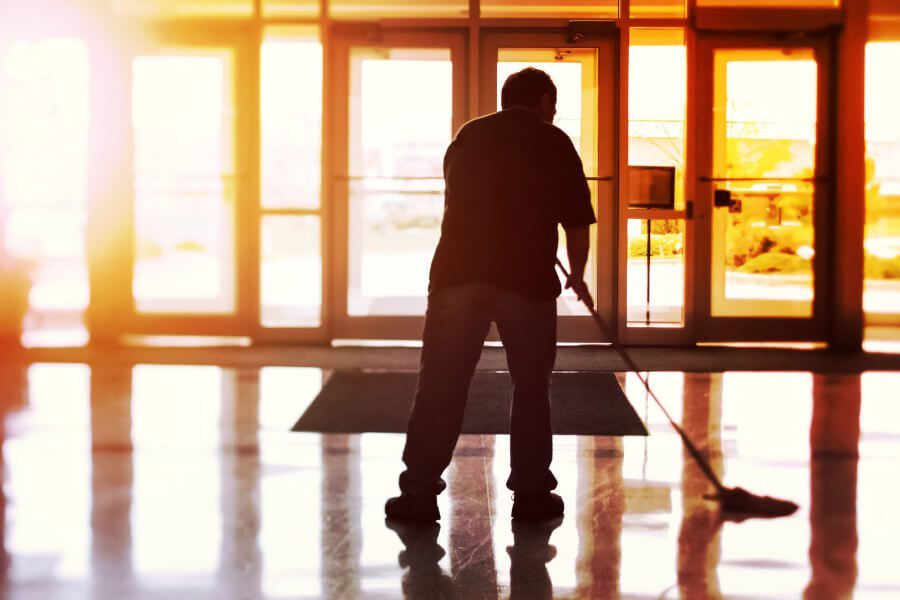 Day porter mopping a commercial entrance